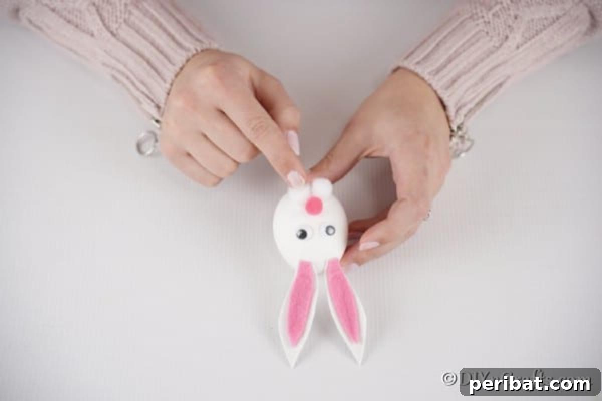 Craft Adorable Easter Bunny Eggs 13 Adding face to the bunny with eyes and pom poms