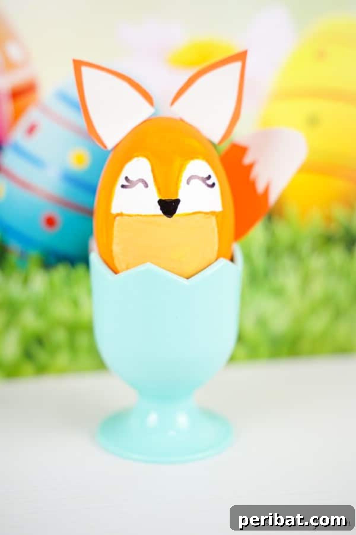 Foxy Fun DIY Easter Egg Project 6 A completed fox Easter egg in a blue cup, displayed in front of a festive Easter background.