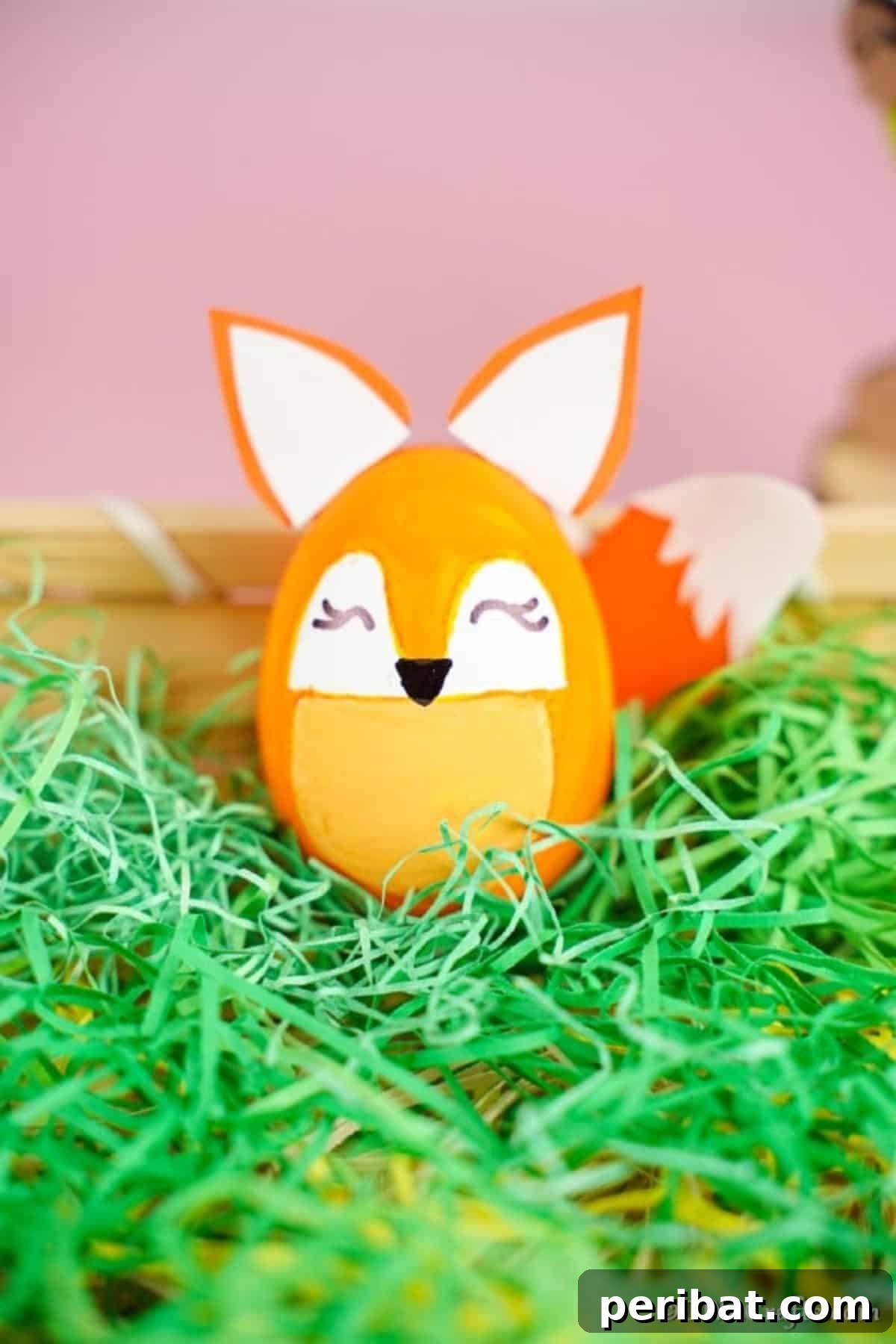 Foxy Fun DIY Easter Egg Project 8 A completed fox Easter egg nestled in a basket filled with vibrant green fake grass, ready for the holiday.