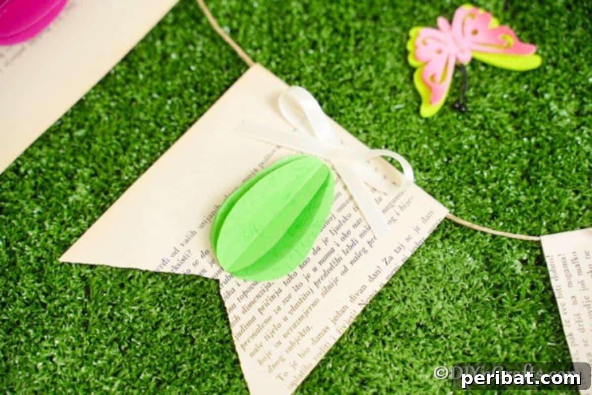 DIY Upcycled Book Page Easter Egg Garland Tutorial 5 Green 3D egg on old book page banner on grass