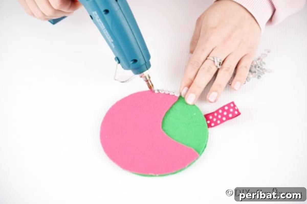 Repurposed CD DVD Wall Storage Pockets 14 Gluing pink paper onto green paper on CD