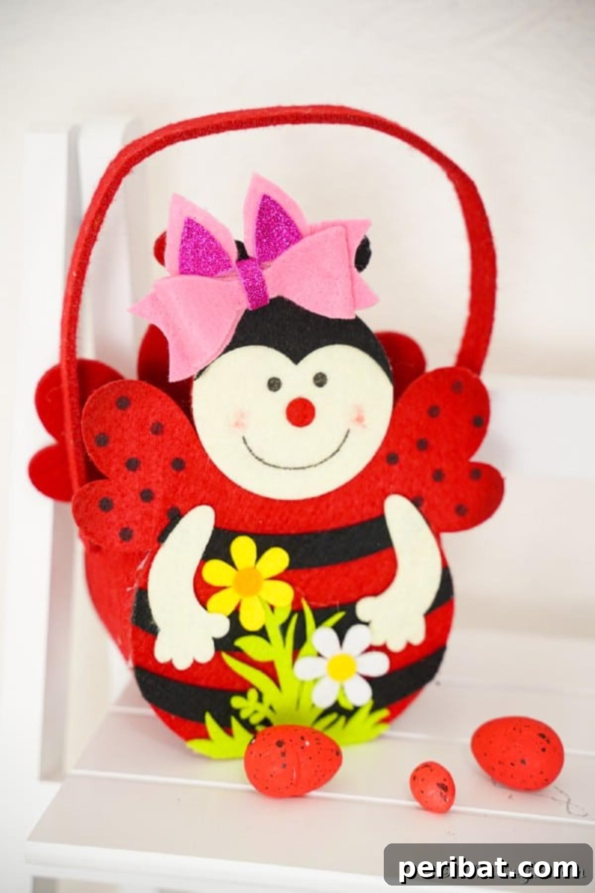 Finished no-sew hair bow resting on a ladybug basket