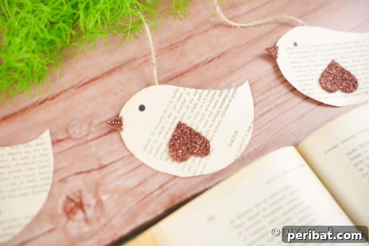 DIY Vintage Book Page Bird Wall Art 3 Old book page hanging birds laying on rustic wood surface next to an open book, highlighting their potential as both decor and bookmarks.