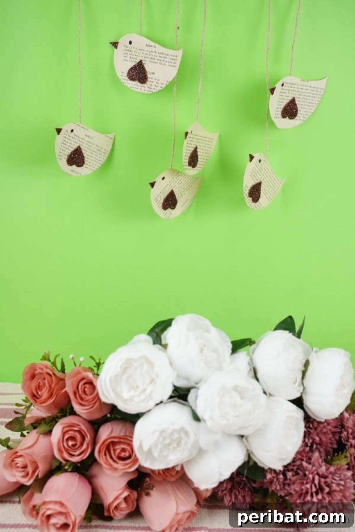 DIY Vintage Book Page Bird Wall Art 4 Delicate paper birds crafted from old book pages, suspended against a soft green wall, showcasing their elegant hanging display.