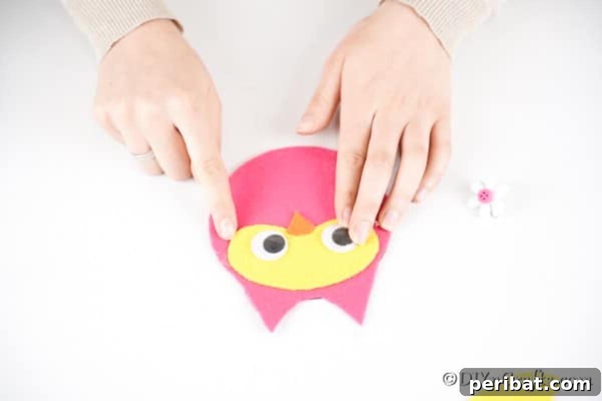 Craft a Whimsical CD Owl Wall Decor 13 Gluing eyes and nose onto owl face