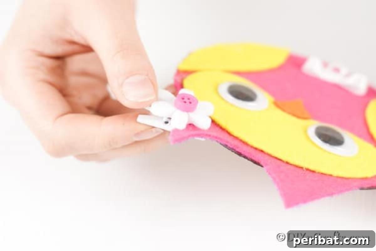 Craft a Whimsical CD Owl Wall Decor 16 Gluing a flower bow on ear of owl cd messenger holder