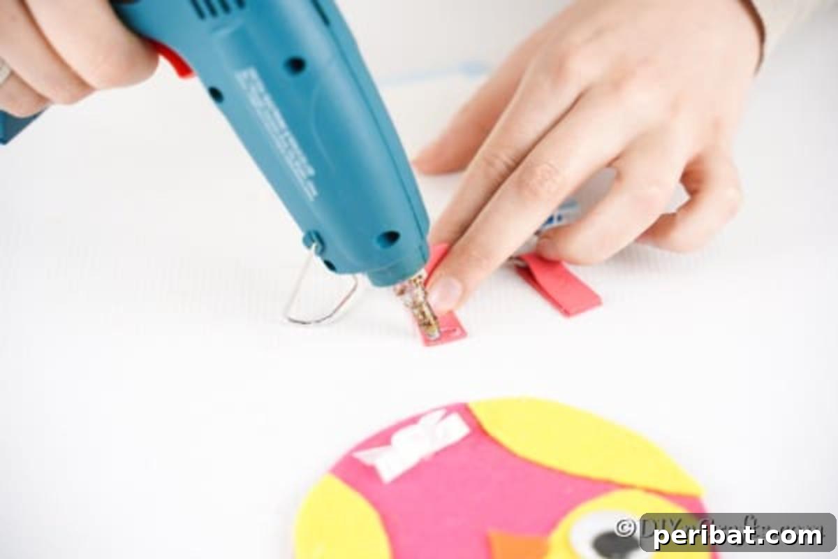 Craft a Whimsical CD Owl Wall Decor 18 Threading felt leg through keyring and gluing together to create legs