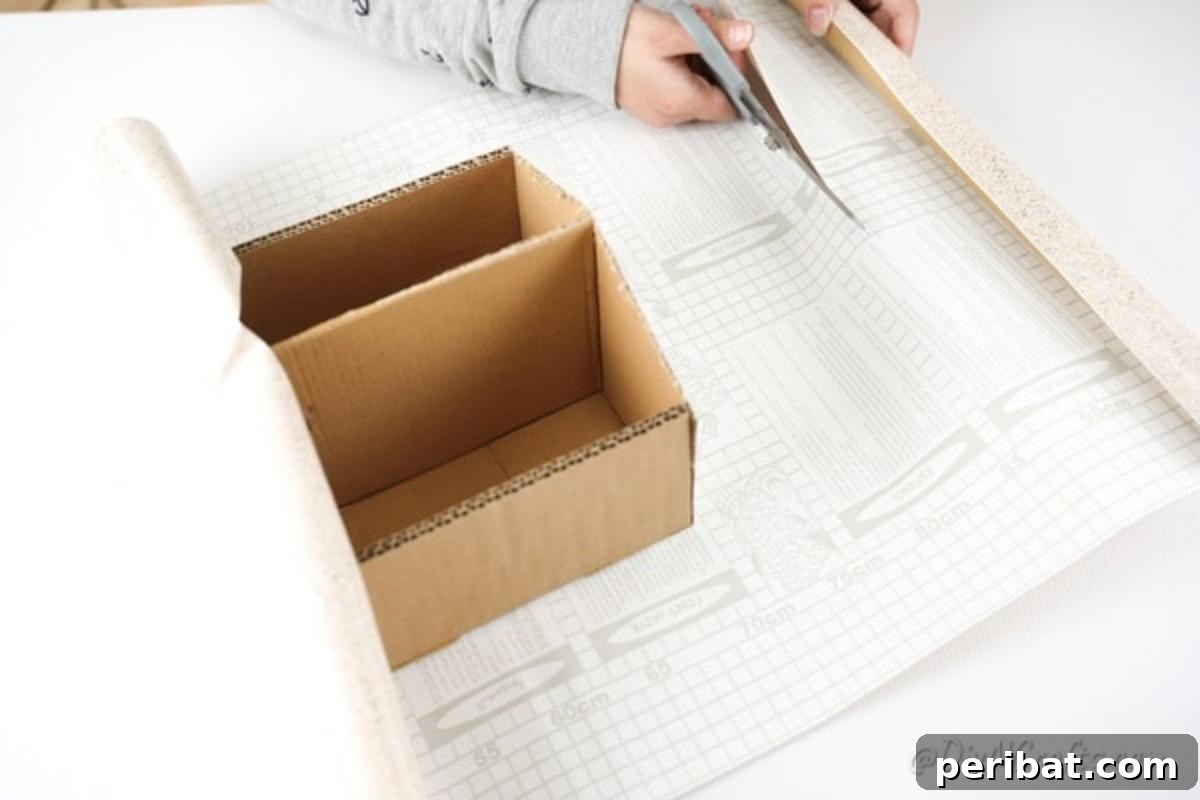 Charming Repurposed Cardboard Organizer 14 Measuring and cutting contact paper, using the cardboard box as a precise template for fitting