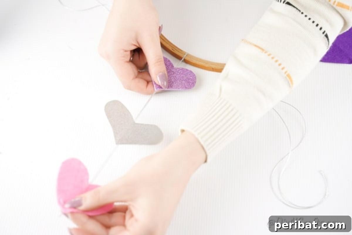 Whimsical Valentine Heart Mobile 12 Gluing hearts into place on twine