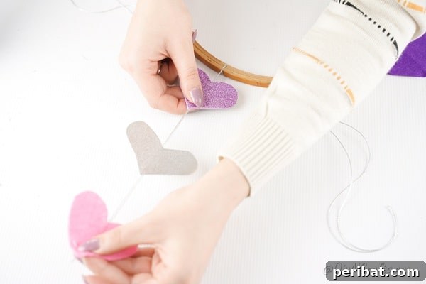 Whimsical Valentine Heart Mobile 20 Gluing hearts into place on twine