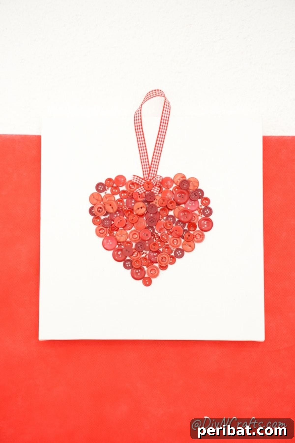 Charming Button Heart Canvas Decor 6 The button heart canvas art piece, displayed against a striking red and white striped wall, highlighting its vibrant colors.