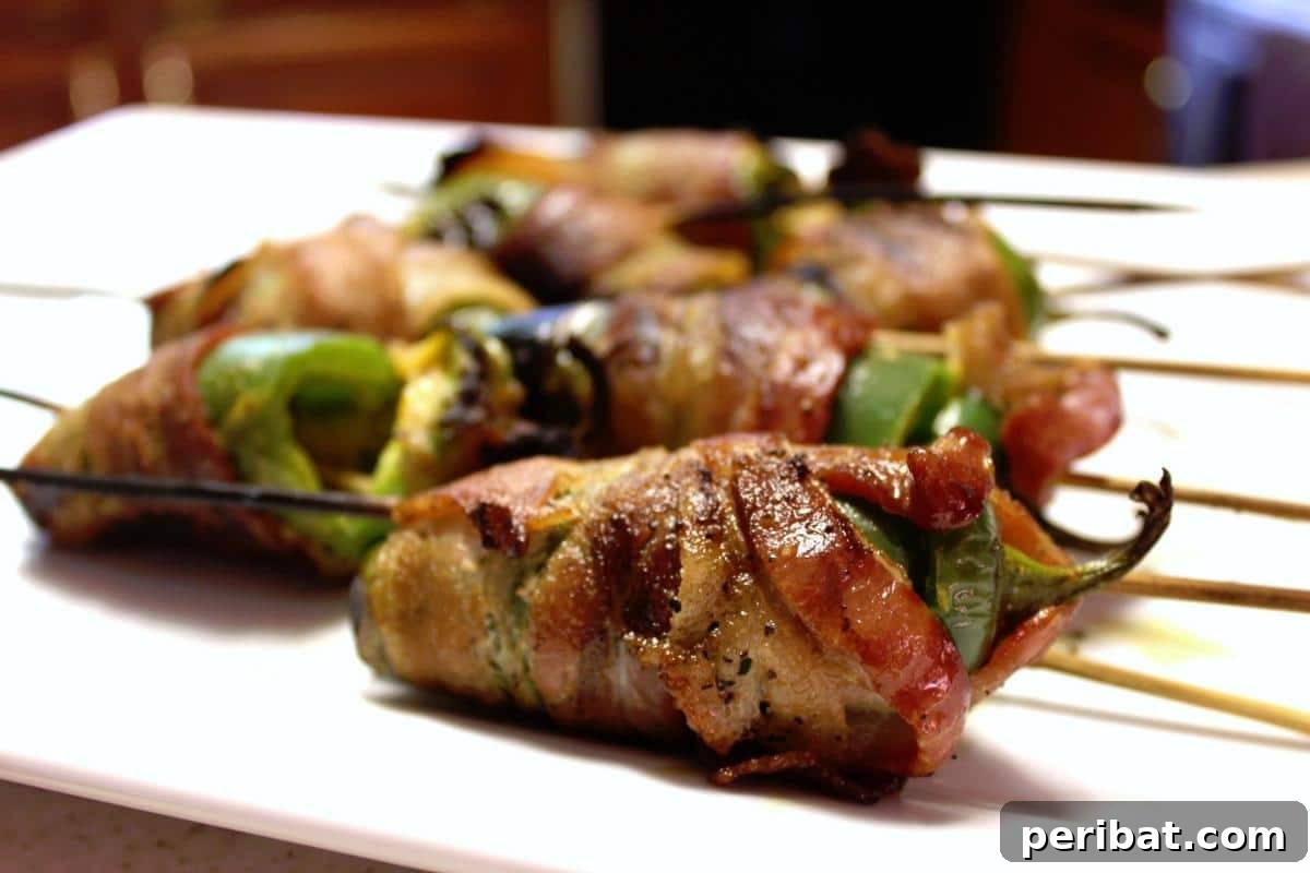 Bacon Beyond Belief: 26 Recipes for an Unforgettable Feast 5 Spicy jalapeno peppers stuffed with cheese and wrapped in crispy bacon, ideal for grilling.