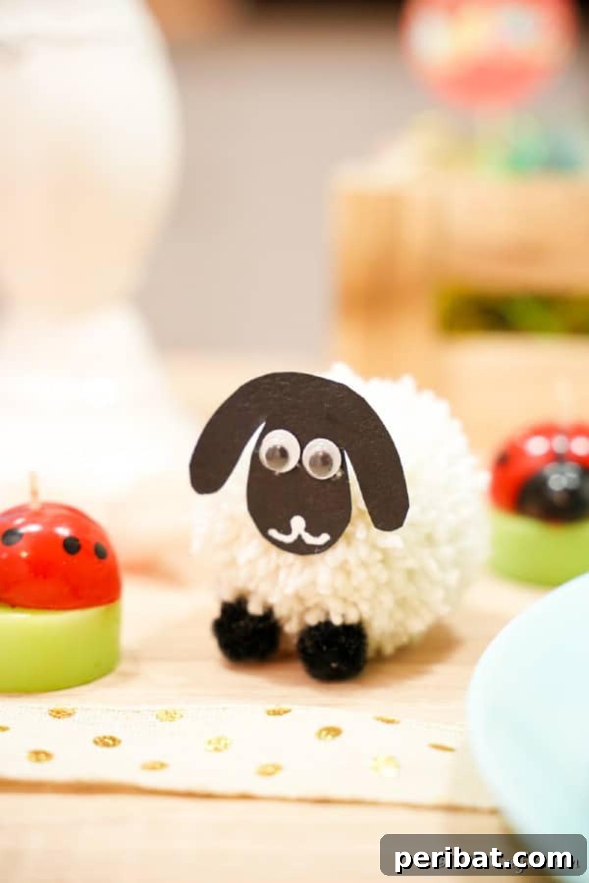 Fluffy Pom-Pom Sheep: A DIY Video Craft Guide 6 A sweet pom pom sheep crafted from yarn, sitting on a wooden table next to a tiny ladybug figurine, creating a miniature charming scene for spring or Easter.