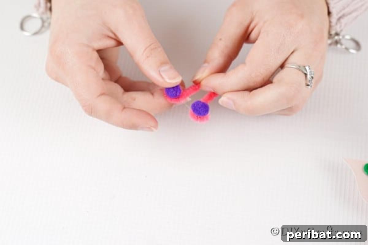 Adding pom poms to the ends of pipe cleaners for butterfly antennae