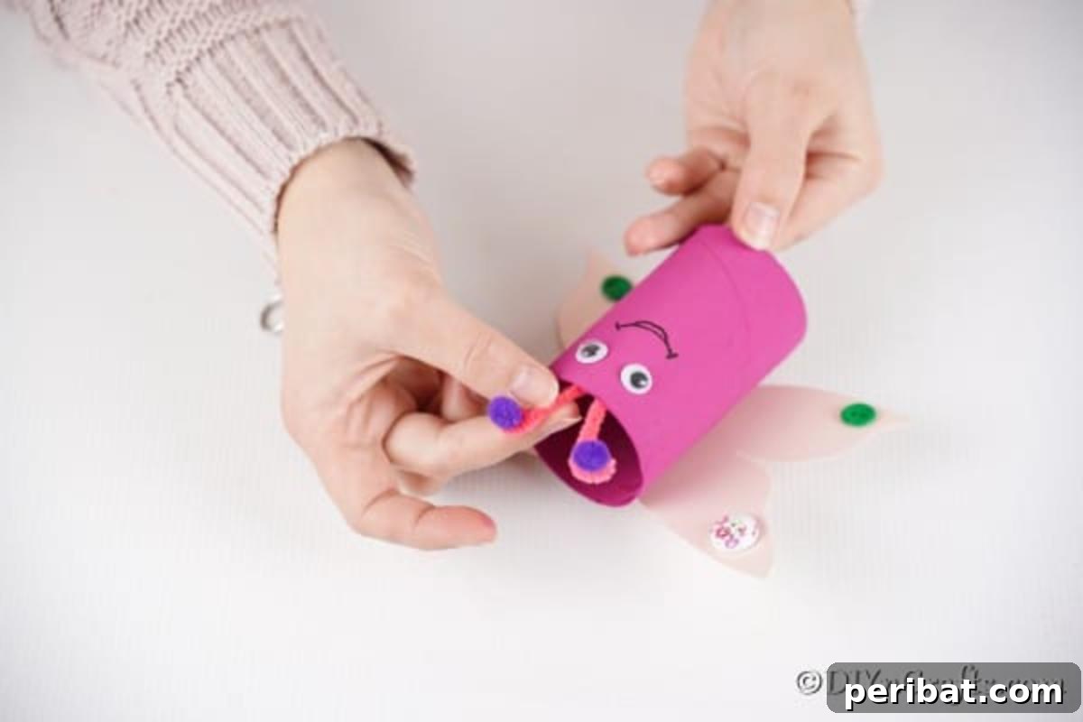 Gluing pipe cleaner antennae to the top of a butterfly craft