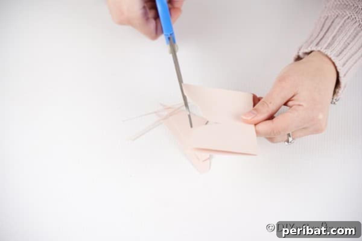 Hands cutting butterfly wings from folded paper