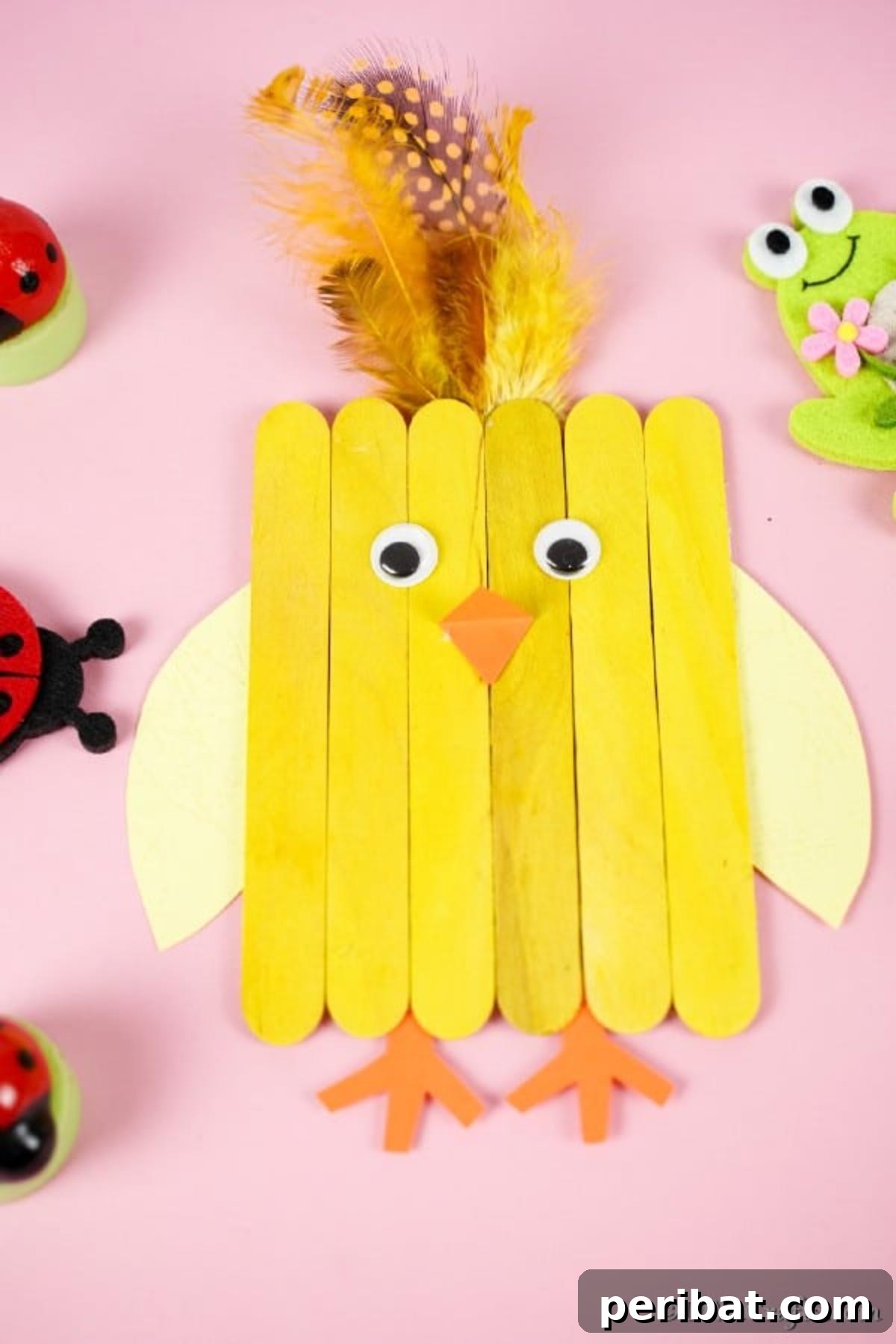 Colorful Craft Stick Chicken Painting 3 Handcrafted popsicle stick chicken resting on a vibrant pink surface, showcasing its simple charm.