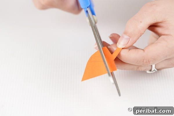 Colorful Craft Stick Chicken Painting 24 Cutting the orange paper beak for the chick.