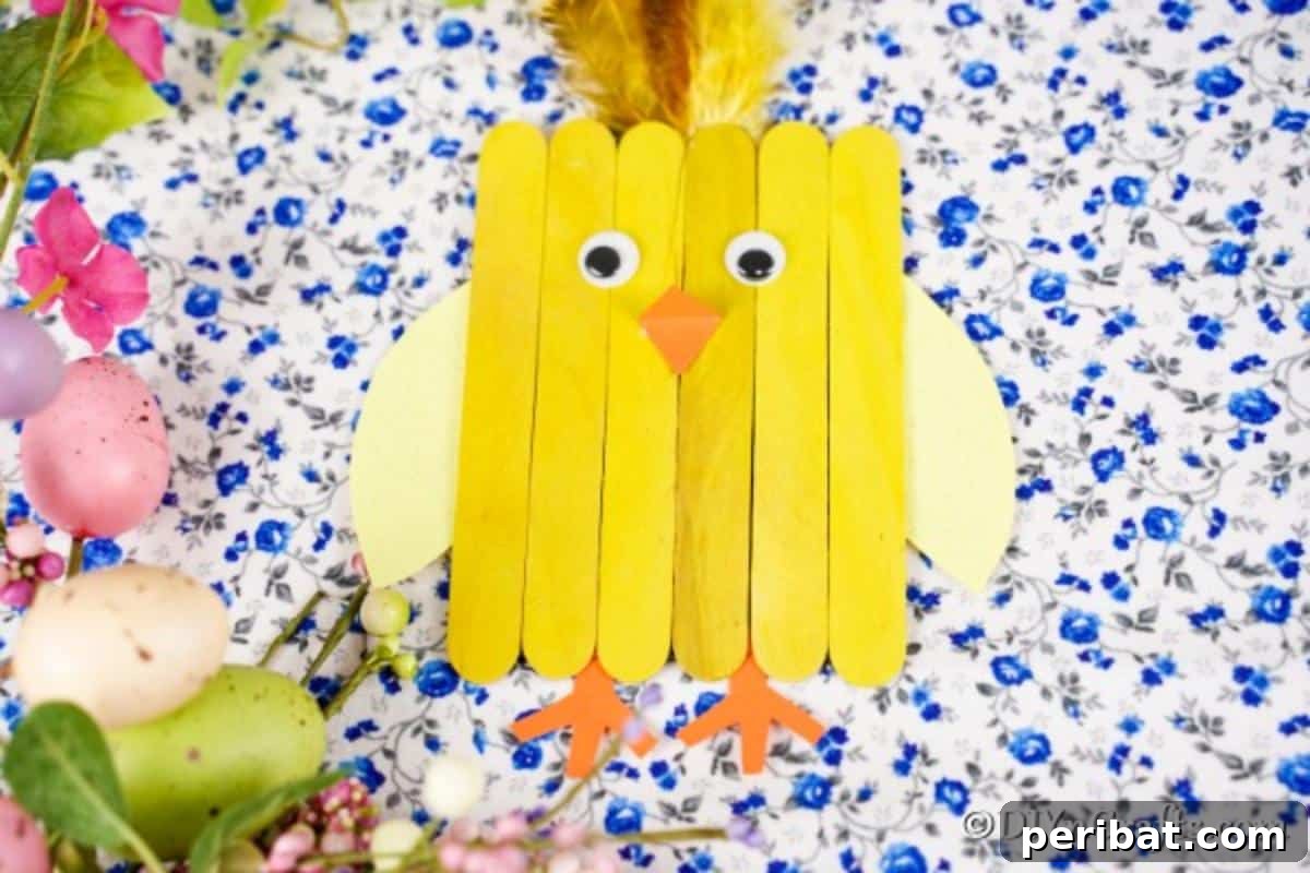 Colorful Craft Stick Chicken Painting 4 A sweet popsicle stick chick craft set against a beautiful blue floral background, highlighting its handmade charm.