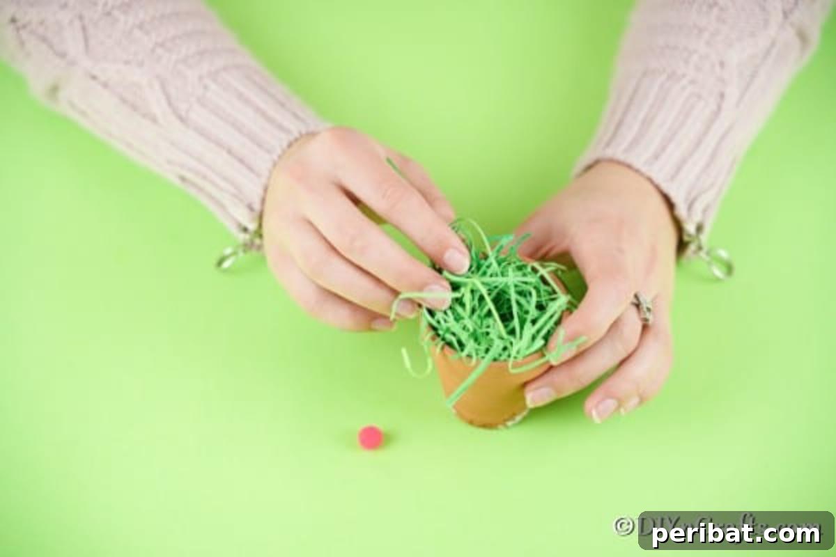 Easter Bunny Bloom Hideaway 7 Stuffing a flower pot with vibrant fake Easter grass, preparing the base for the bunny