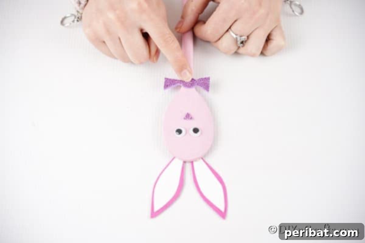 Gluing bow to pink spoon