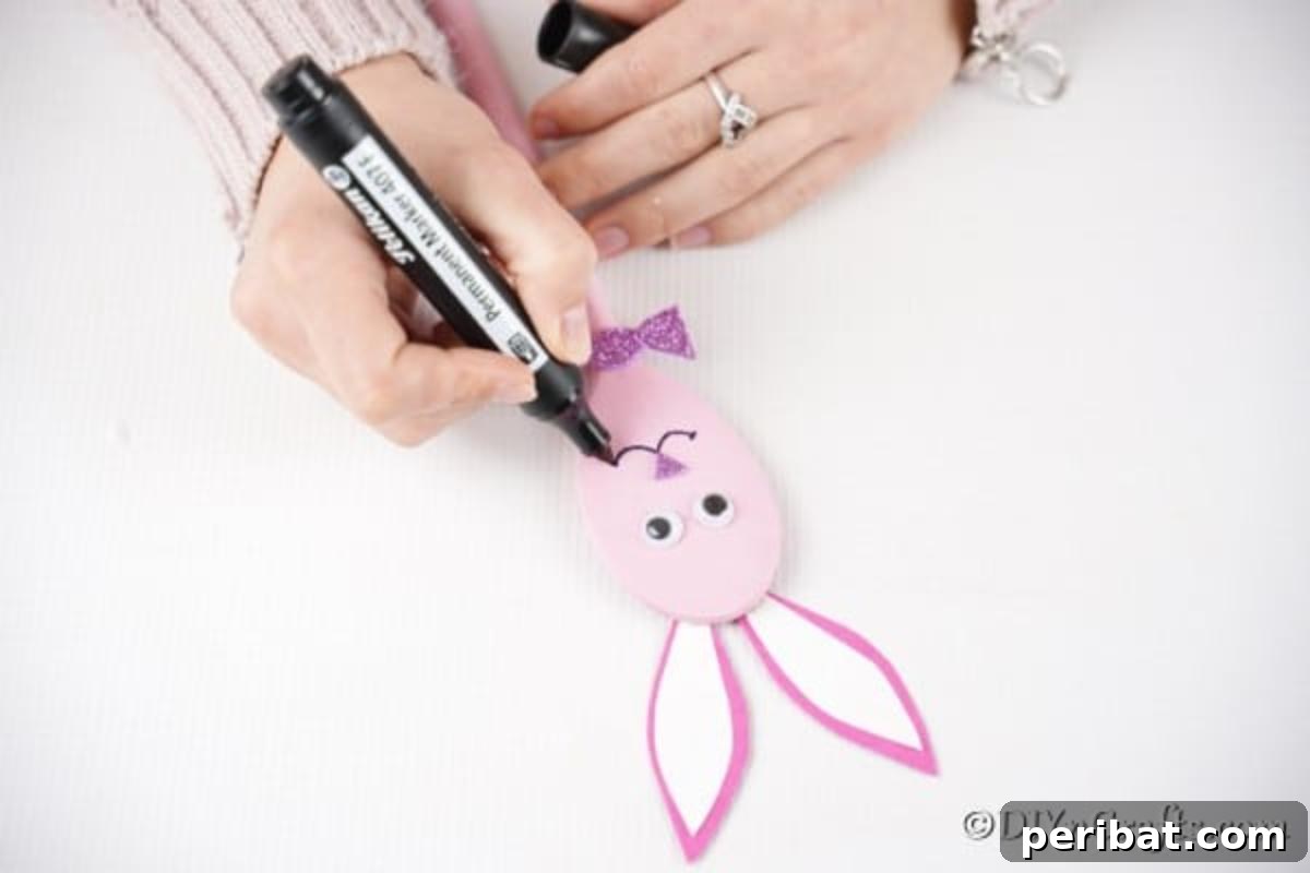 Drawing face on pink spoon