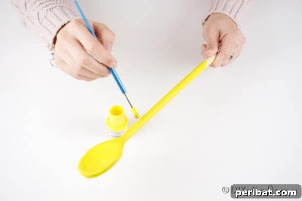 Painting wooden spoon yellow