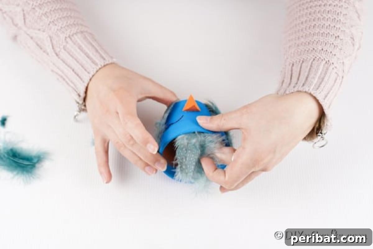 Whimsical Hand-Painted Bird Planter Charm 11 Gluing blue feathers inside the rim and on the sides of the bird pot