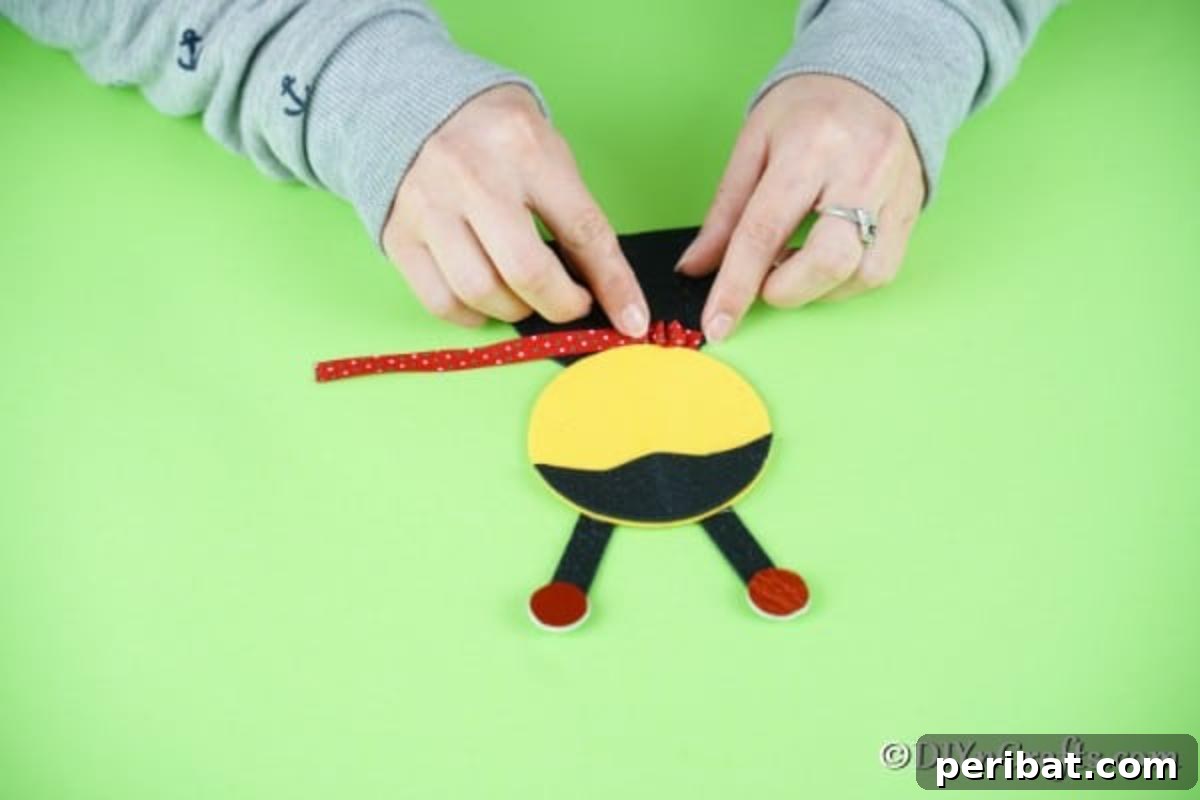 Adding a ruffled ribbon collar to the ladybug's neck