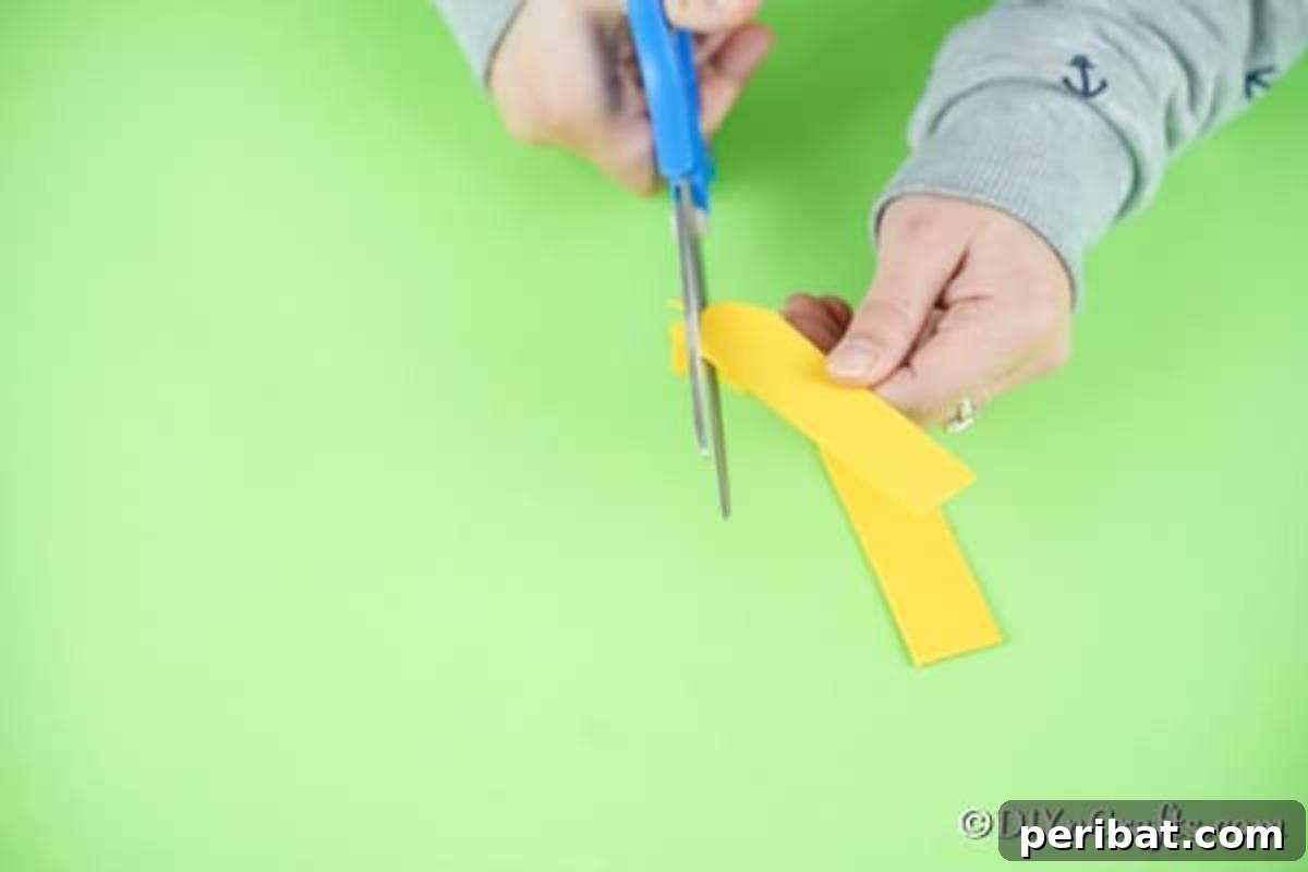 Cutting out the ladybug's arms from yellow foam paper
