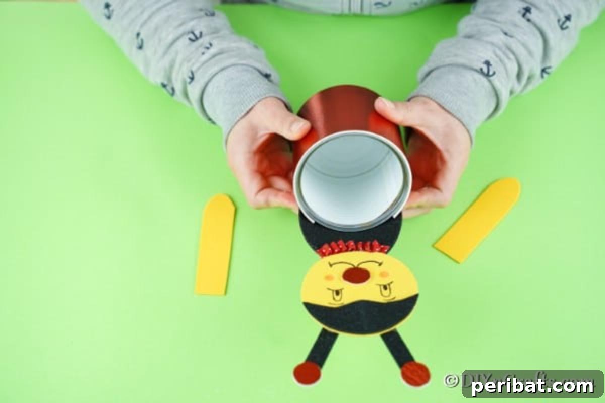 Attaching the ladybug's body to the decorated tin can