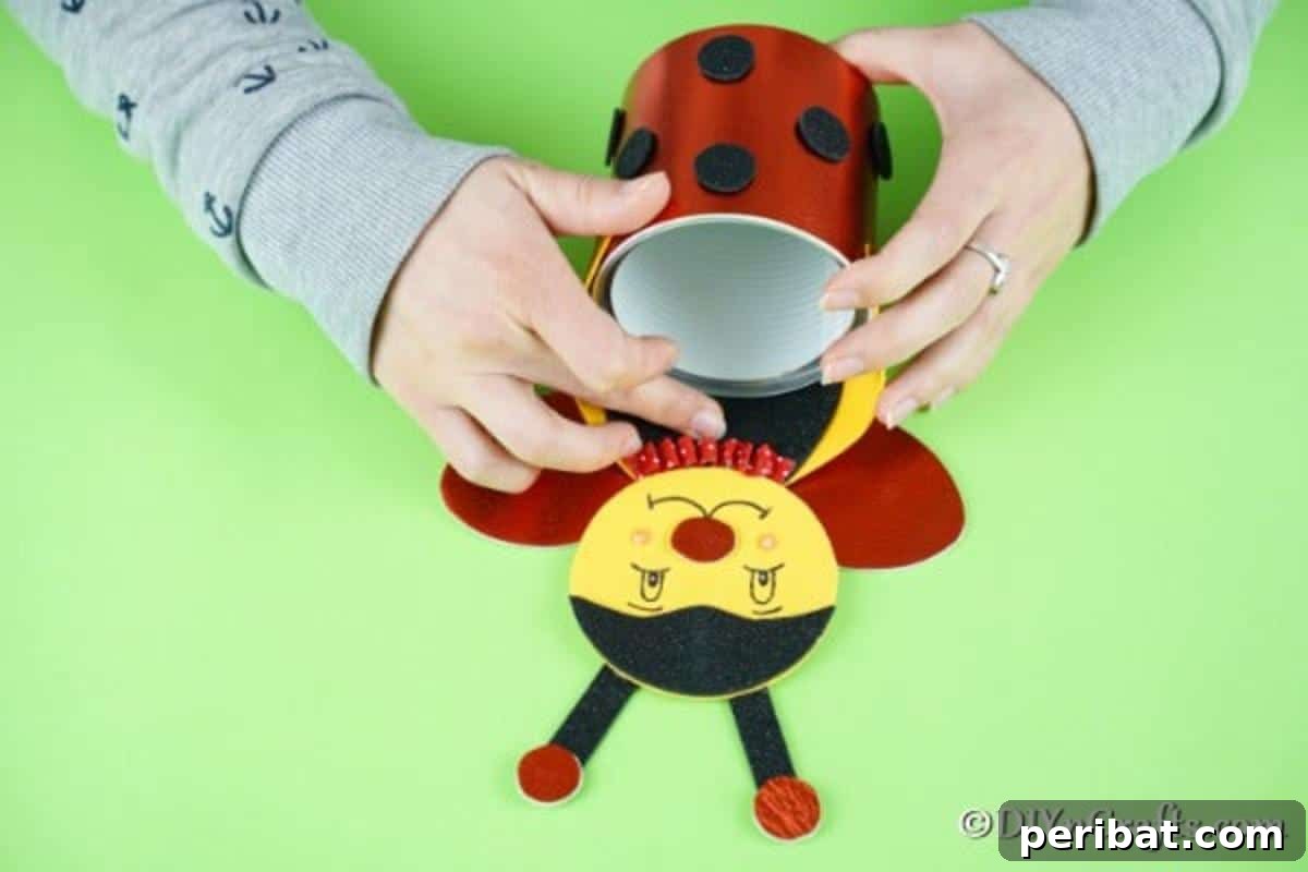 Gluing the finished wings onto the ladybug's back