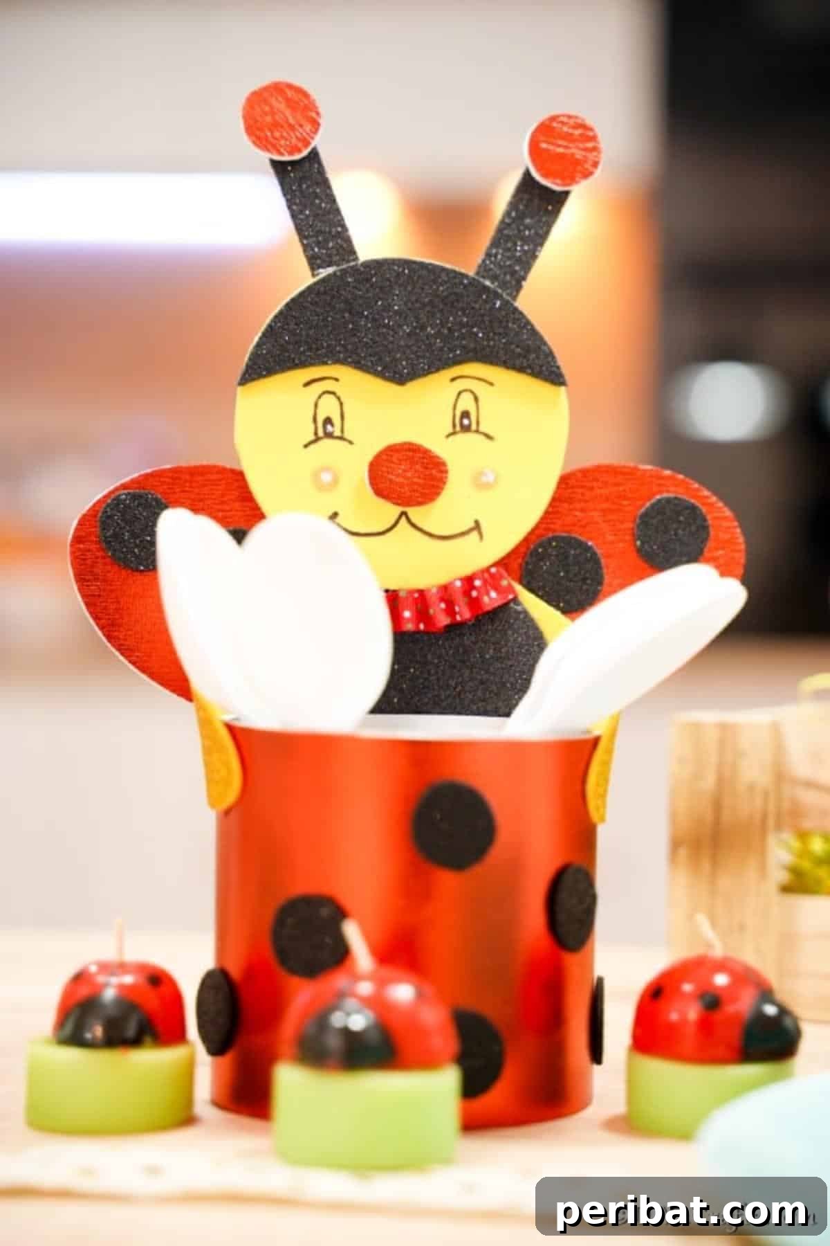 Ladybug Tin Can Organizer filled with Spoons on a Table