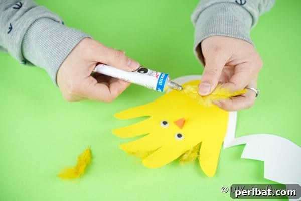 Gluing feathers to top of handprint