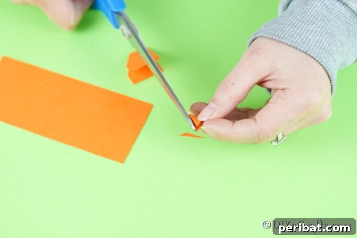 Simple Repurposed Bucket Spring Chicken 11 Cutting a small triangular beak shape from orange craft paper