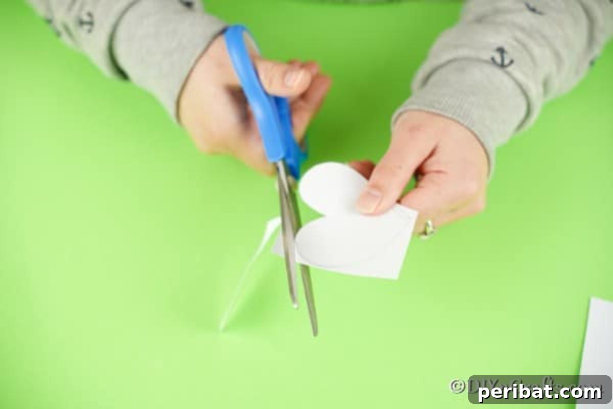 Simple Repurposed Bucket Spring Chicken 8 Carefully cutting out the drawn heart shapes from the white paper
