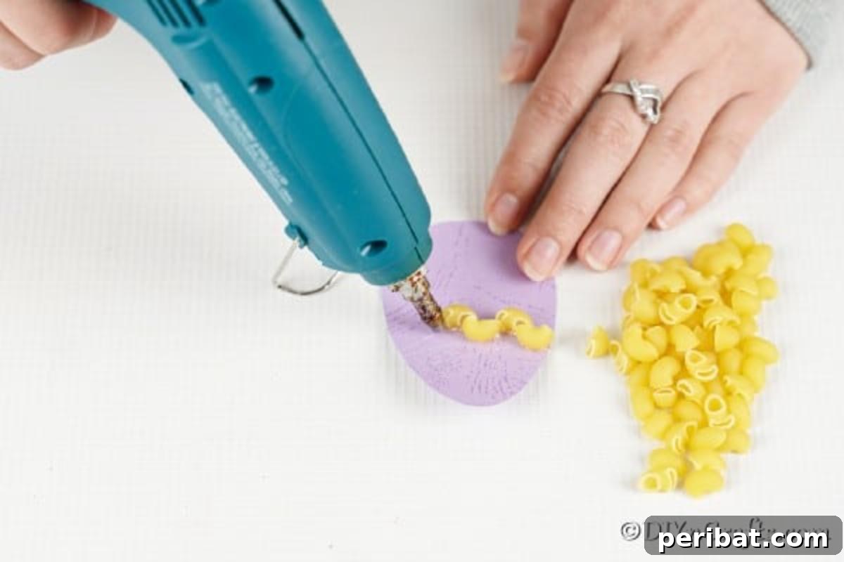 Whimsical Pasta Easter Egg Garland 12 Hands meticulously gluing various pasta pieces onto paper egg cutouts