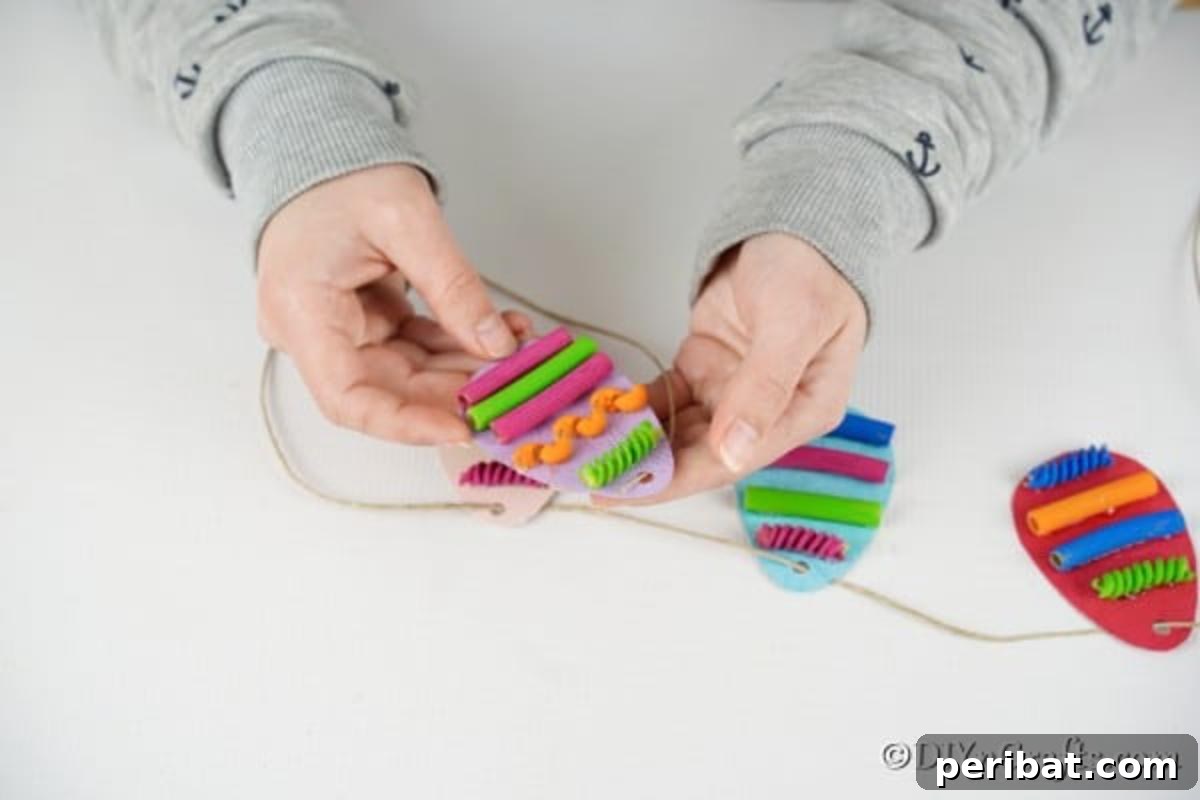 Whimsical Pasta Easter Egg Garland 17 Hands carefully stringing twine through the punched holes of paper eggs to form a garland