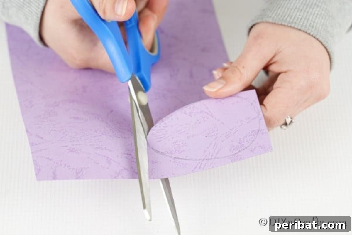Whimsical Pasta Easter Egg Garland 10 Hands carefully cutting an egg shape from a piece of paper