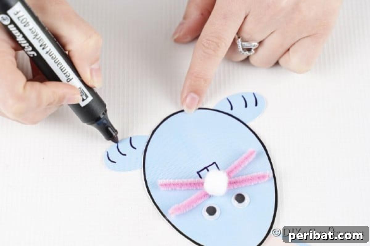 A black marker drawing bunny teeth below the nose and details on the feet of the Easter bunny card.