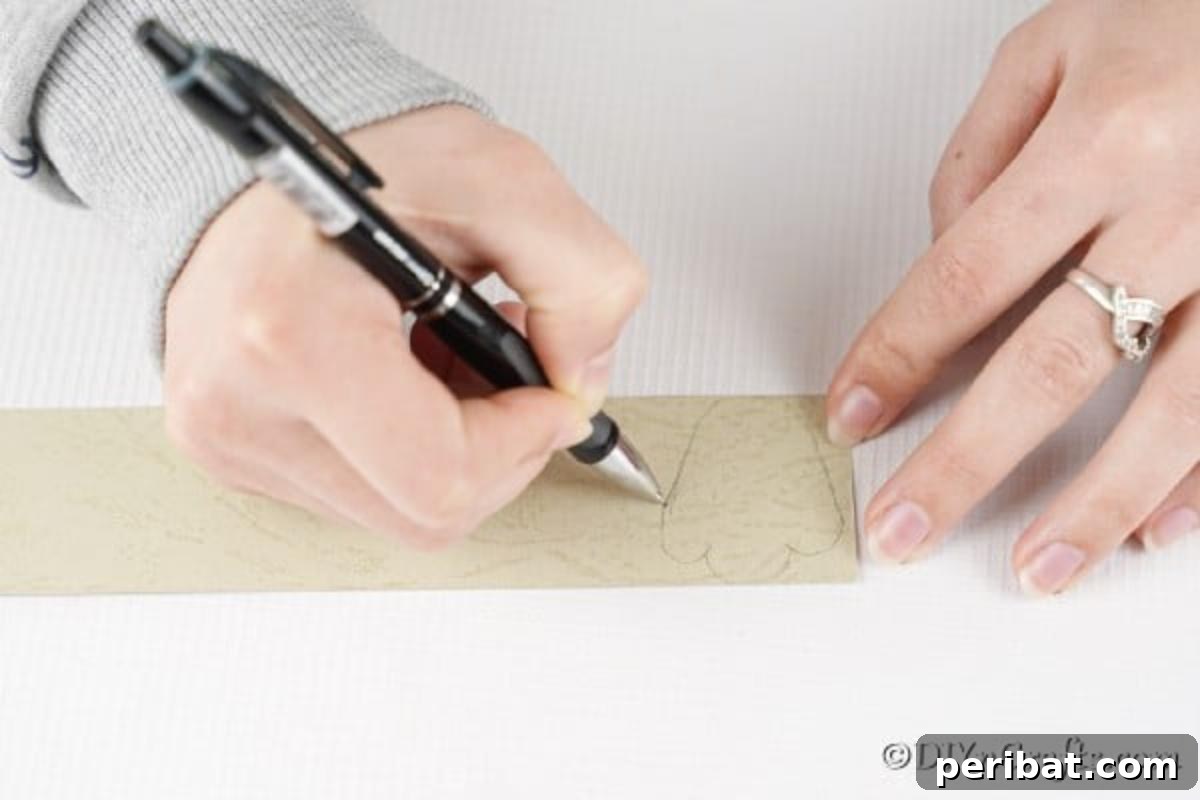 DIY Easter Treat Pouch Video Guide 12 A hand drawing bunny foot shapes onto white paper, with pink paper visible for accents