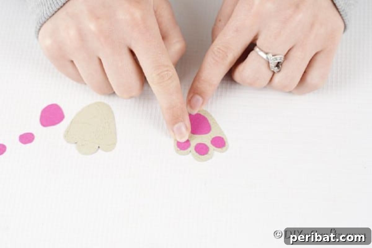 DIY Easter Treat Pouch Video Guide 13 Hands gluing the pink paw pad accents onto the white bunny foot shapes