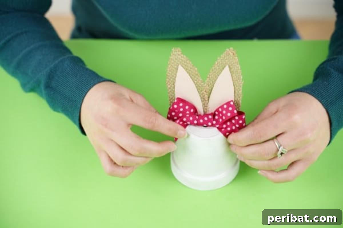 Charming Repurposed Planter Bunnies for Easter 11 Adding a pink ribbon bow between the bunny's ears on the flower pot.
