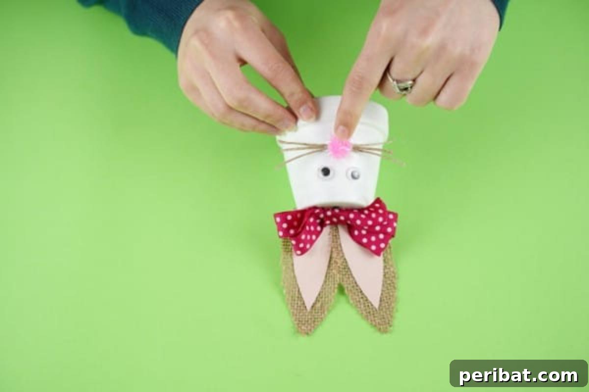 Charming Repurposed Planter Bunnies for Easter 13 Gluing rustic twine whiskers and a pink pom-pom nose onto the bunny.