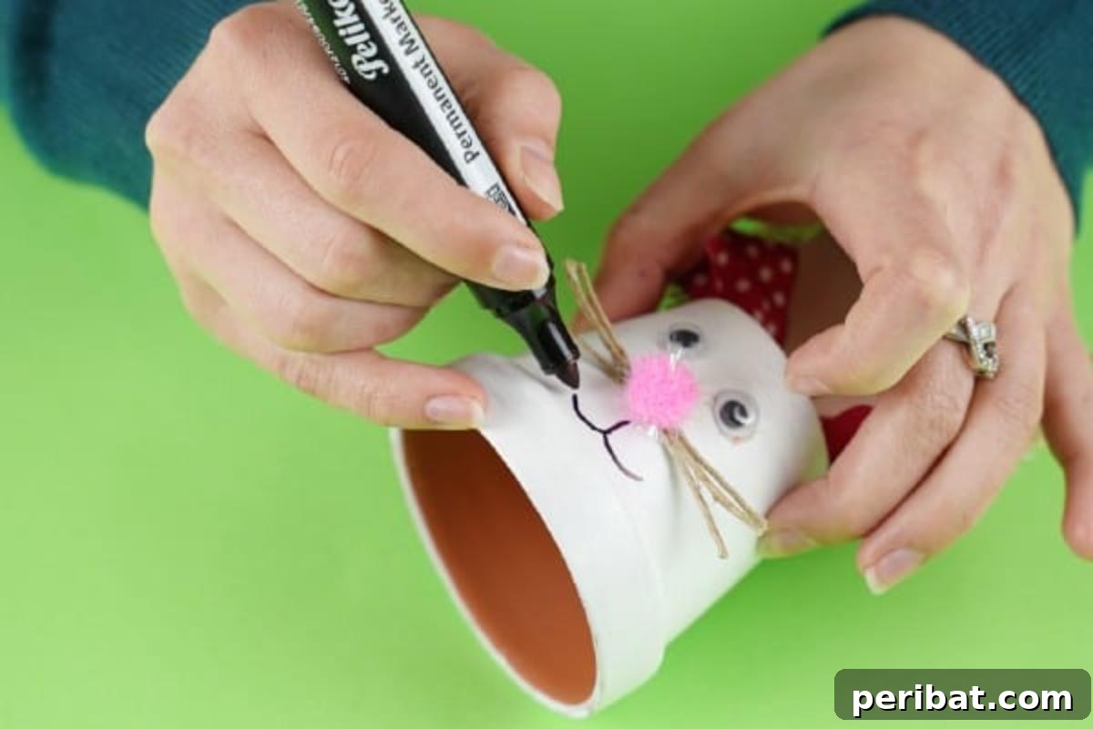 Charming Repurposed Planter Bunnies for Easter 14 Drawing the mouth on the flower pot bunny with a black marker.