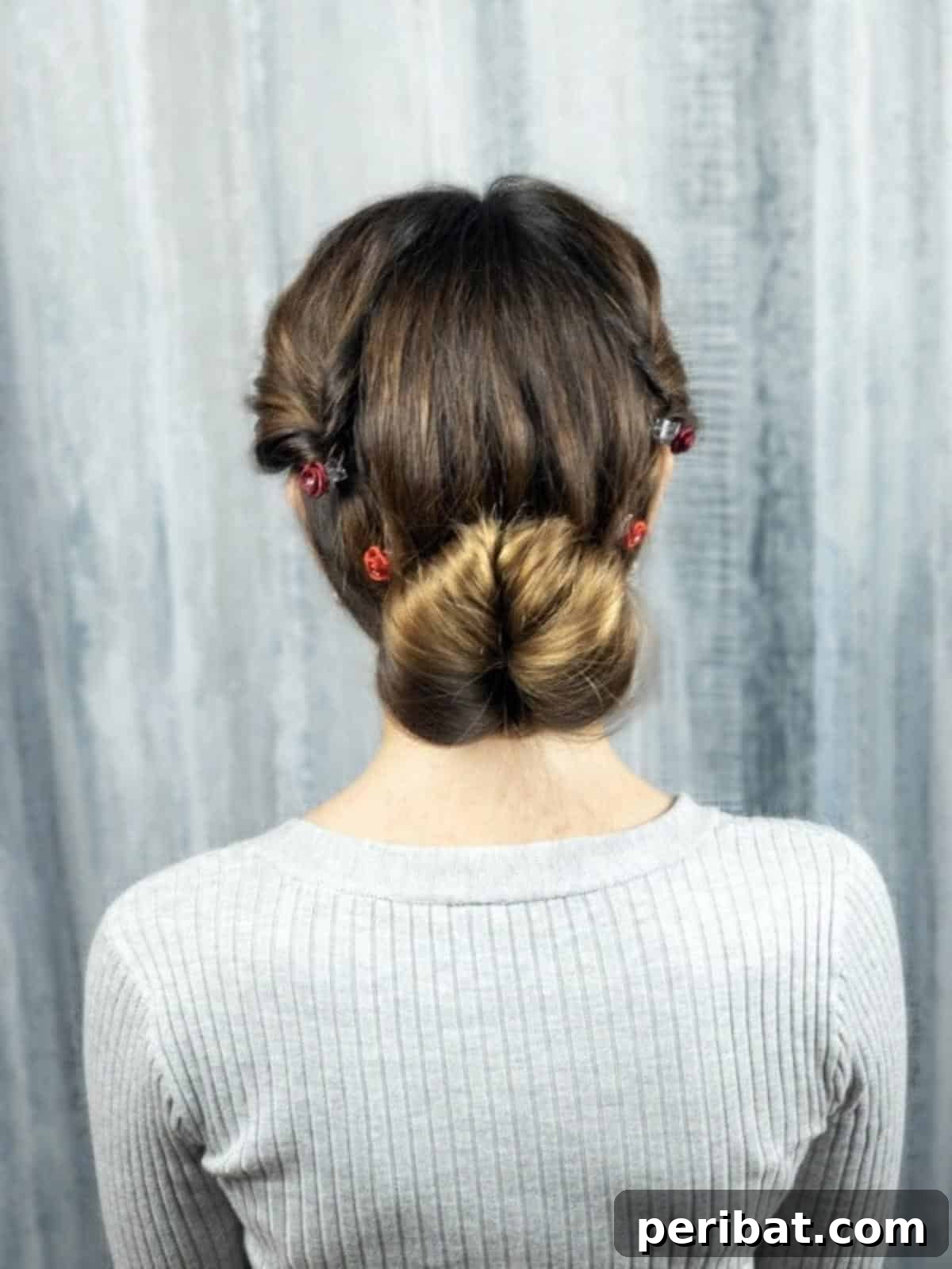 Rose-Kissed Low Bun Updo 20 A stunning final shot of the completed low bun updo hairstyle, adorned with delicate rose accents, showcasing its elegance and beauty.