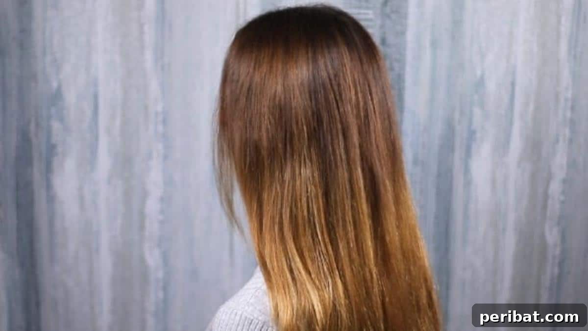 Rose-Kissed Low Bun Updo 6 A person meticulously brushing long brunette hair to remove tangles, preparing it for an elegant updo.