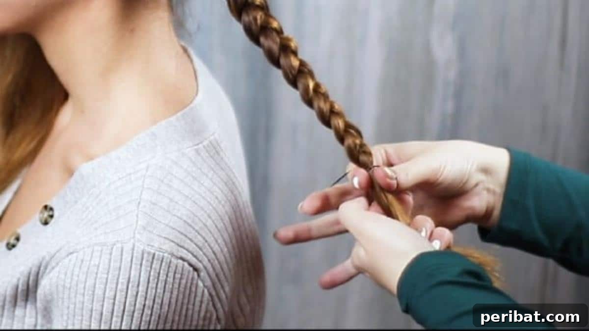 Gorgeous Double Dutch Braids: Step-by-Step Video Guide 10 Securing the end of the completed braid with a hair tie