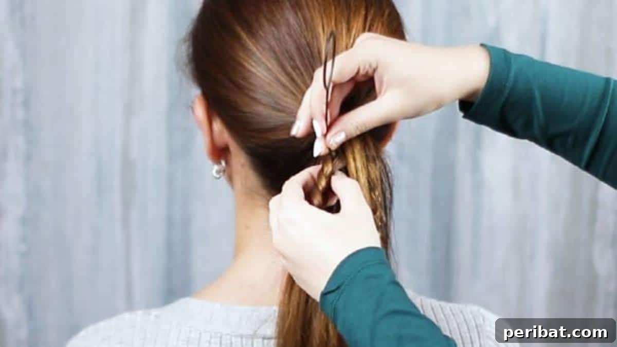 The Topsy Tail tool being inserted into the beginning section of one of the small braids