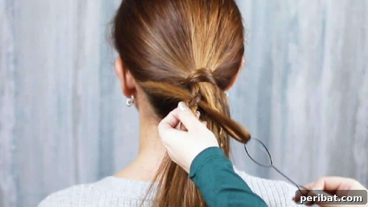 Loose hair being threaded through the Topsy Tail loop, ready to be pulled through the braid